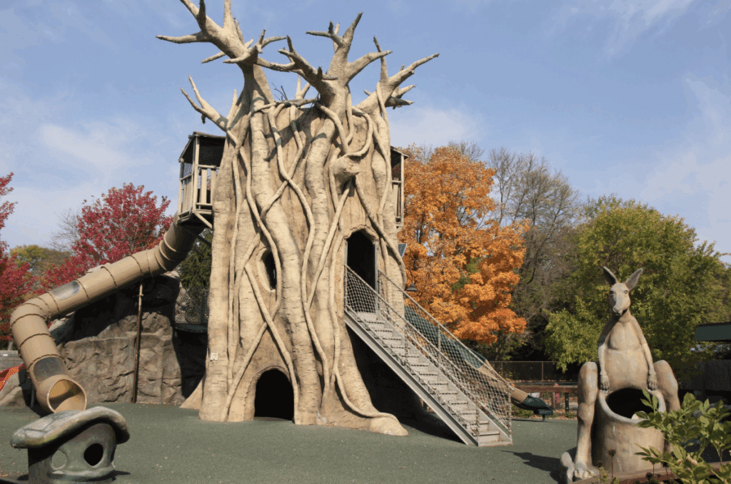 Large natural playground at Henry Vilas Zoo with autumn trees in the background.